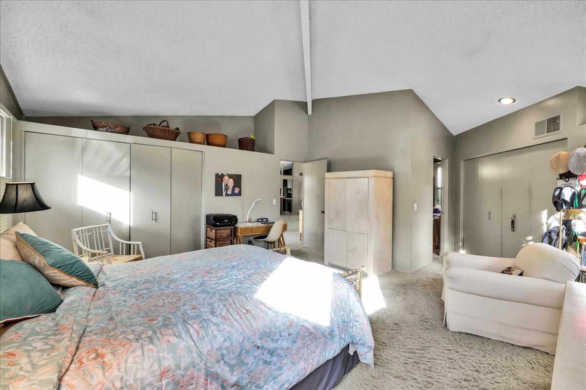 37800 Da Vall Drive, Unit 1 Rancho Mirage, CA 92270 - Photo 17 of 36 a bedroom with a bed a couch and dresser