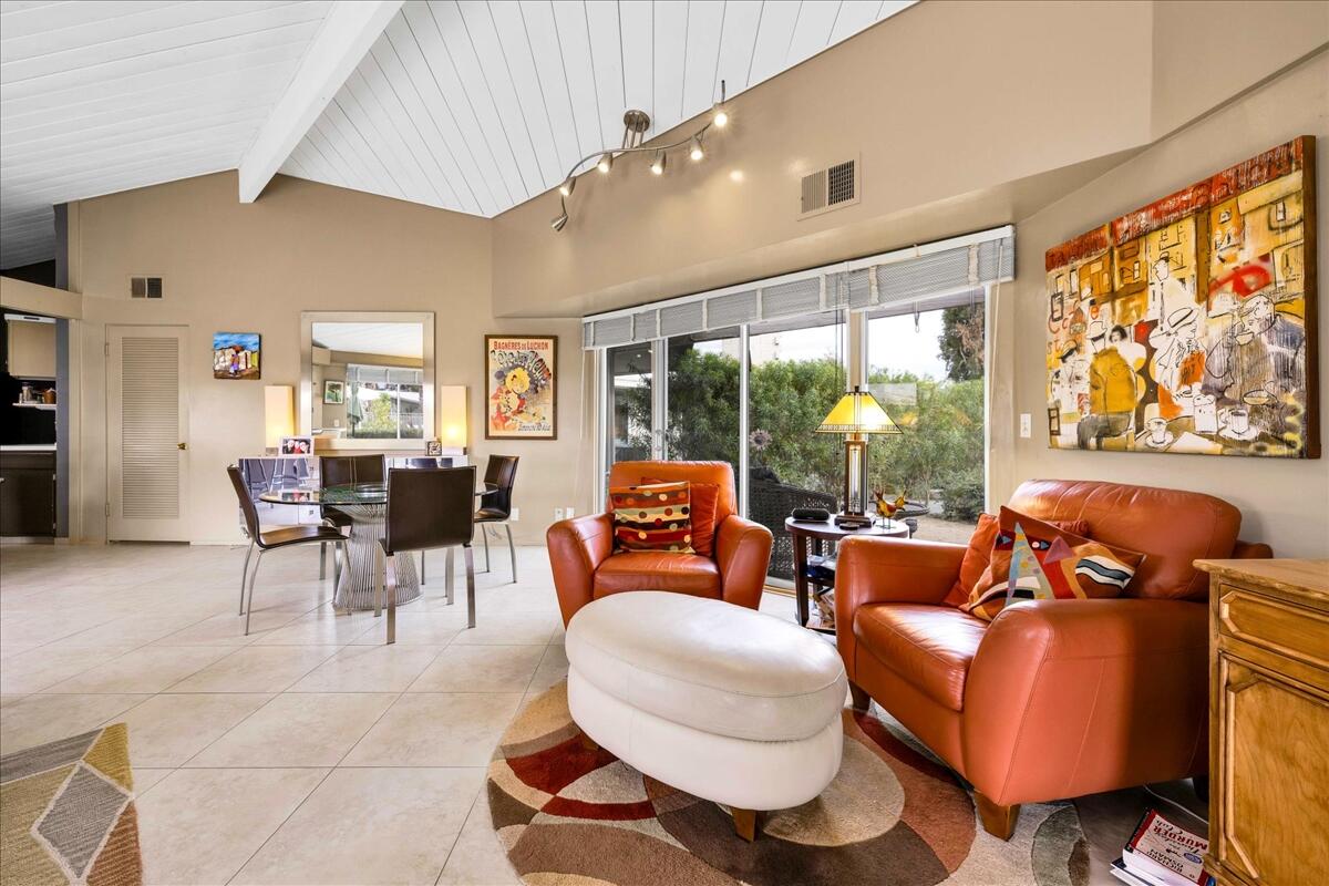 37800 Da Vall Drive, Unit 1 Rancho Mirage, CA 92270 - Photo 9 of 36 a living room with furniture a fireplace and large windows