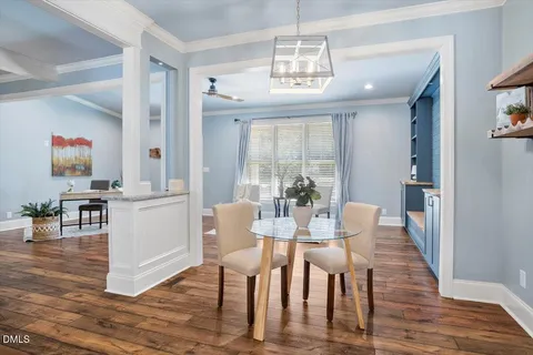 a view of a dining room with furniture a chandelier and wooden floor