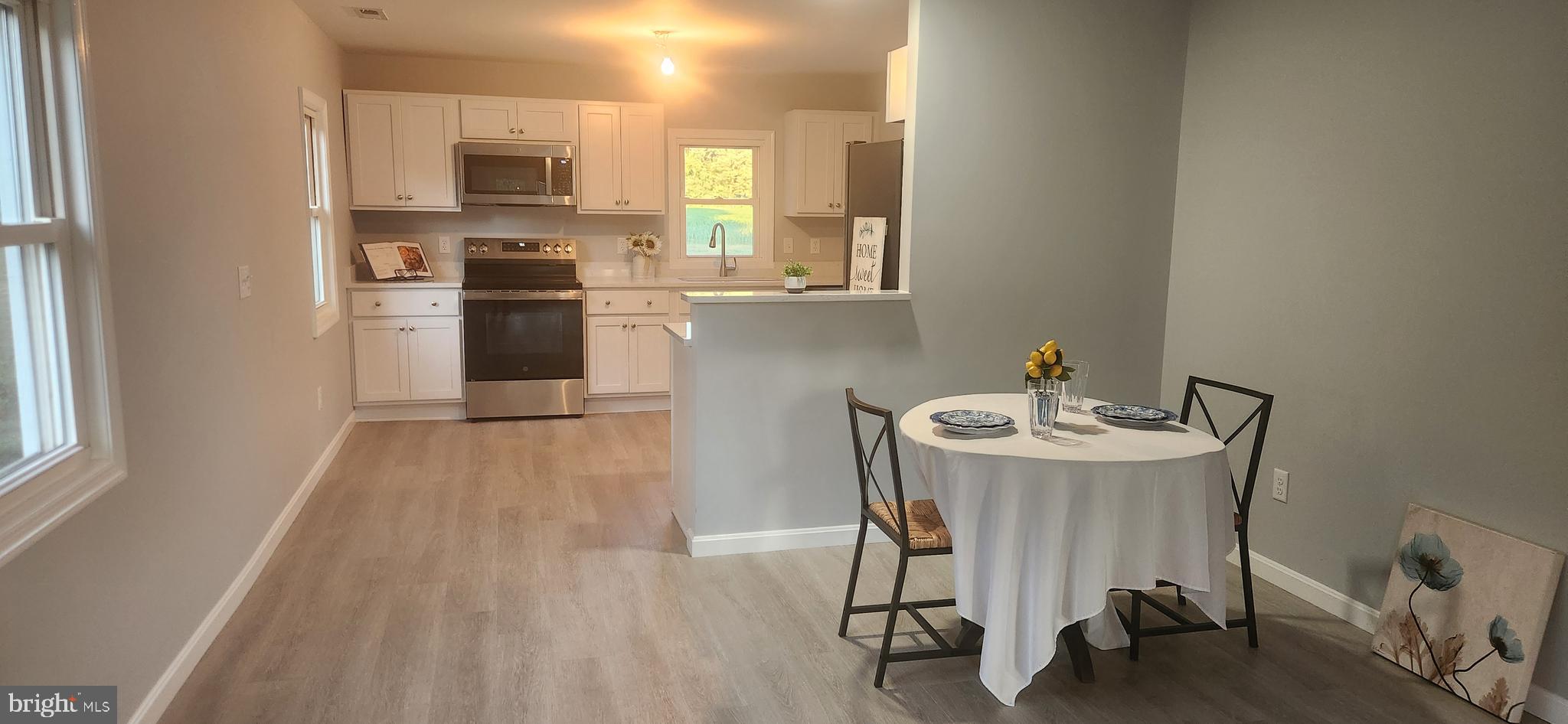 10819 Greensboro Road Denton, MD 21629 - Photo 16 of 27 a kitchen with a table chairs refrigerator and microwave
