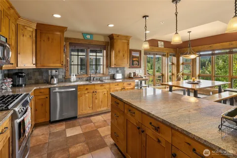a kitchen with stainless steel appliances granite countertop a sink counter space cabinets and a large window