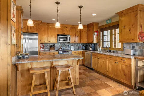 a kitchen with stainless steel appliances kitchen island granite countertop a sink and cabinets