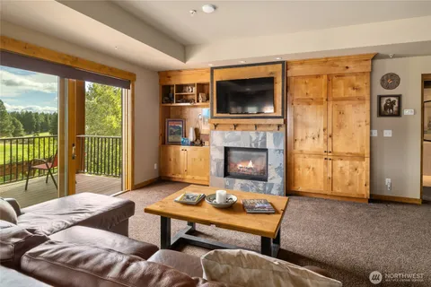 a living room with furniture a flat screen tv and a fireplace