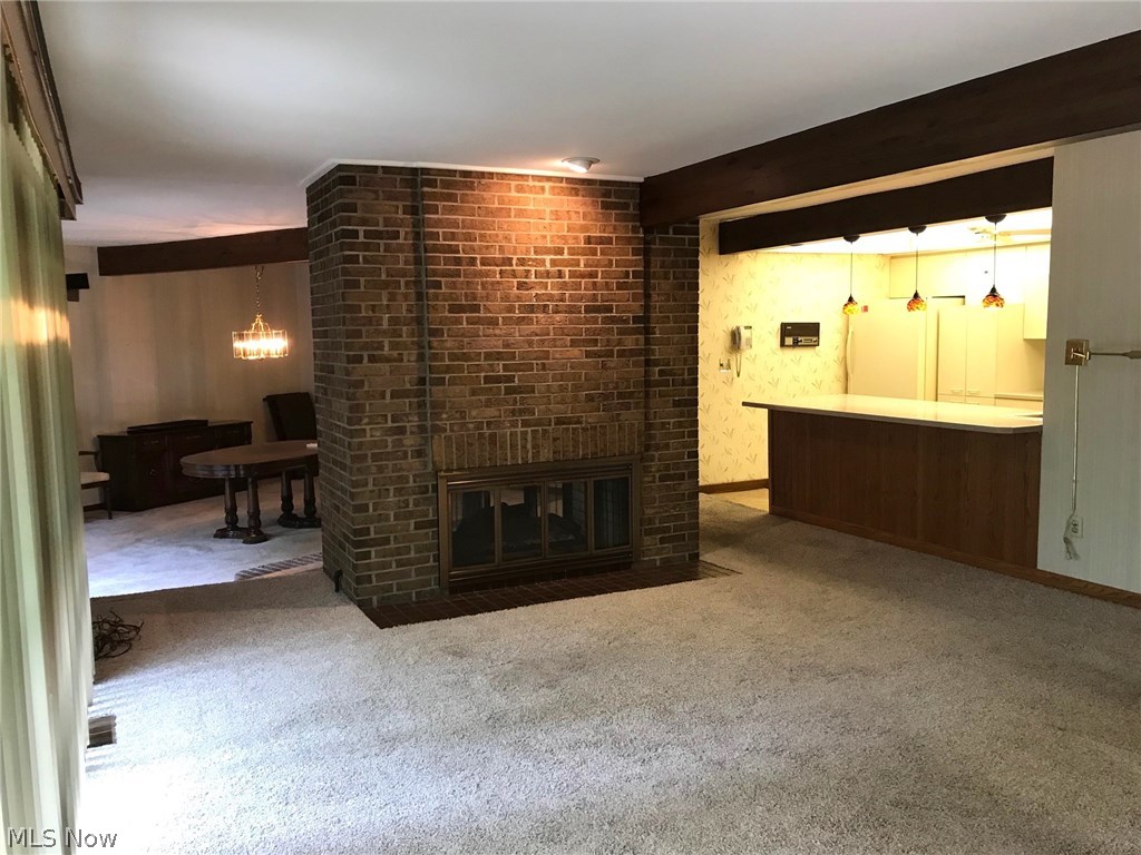 297 North Road Northeast Warren, OH 44483 - Photo 11 of 35 View of 2-way fireplace with gas logs showing living room, kitchen, and dining room areas.