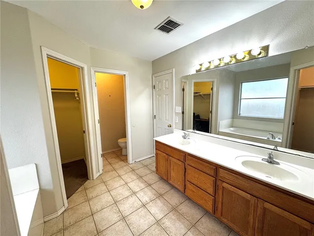 a spacious bathroom with a double vanity sink a mirror and a shower