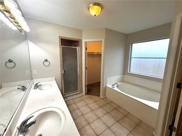 a bathroom with a tub sink and mirror