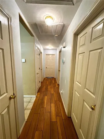 a view of a hallway with wooden floor and staircase