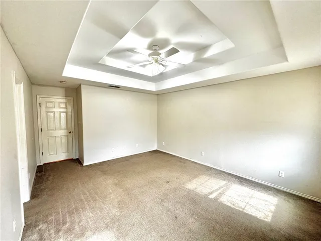 an empty room with a ceiling fan and window