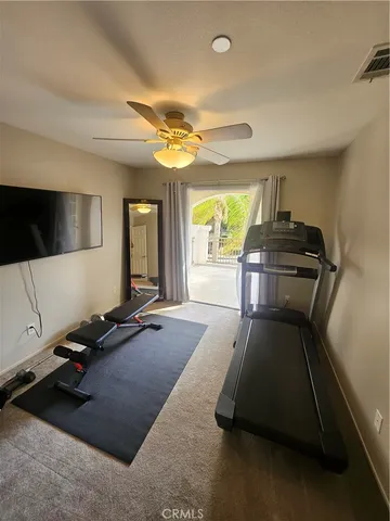 a room with gym equipment and a flat screen tv