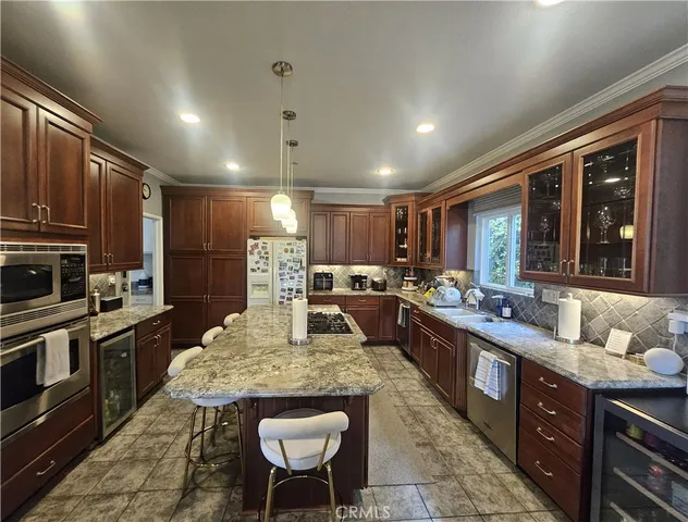 a large kitchen with lots of counter space a sink a window and stainless steel appliances