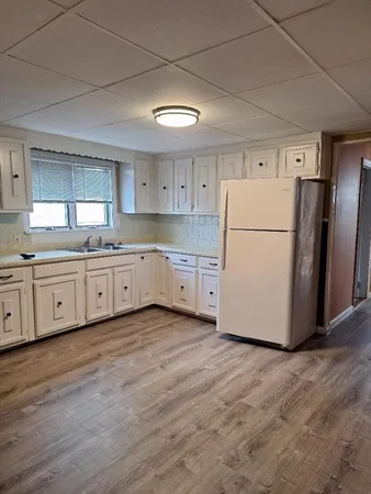 a kitchen with a white refrigerator a sink a stove a microwave and cabinets