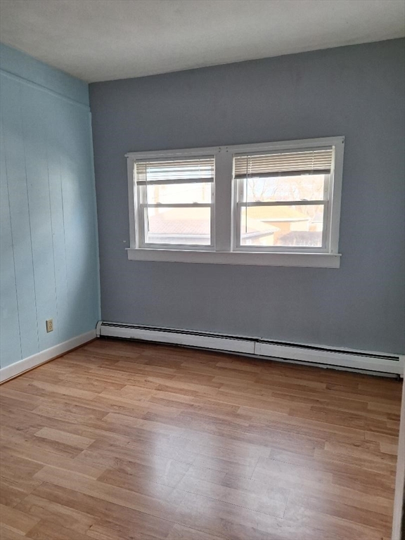 71 Adams Street, Unit 1 Medford, MA 02155 - Photo 7 of 7 a view of an empty room with wooden floor and a window
