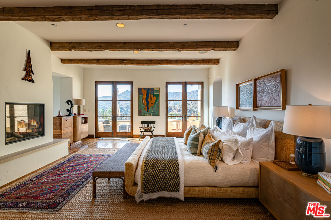 1101 Cold Canyon Road Calabasas, CA 91302 - Photo 25 of 60 a spacious bedroom with a bed a table and dresser