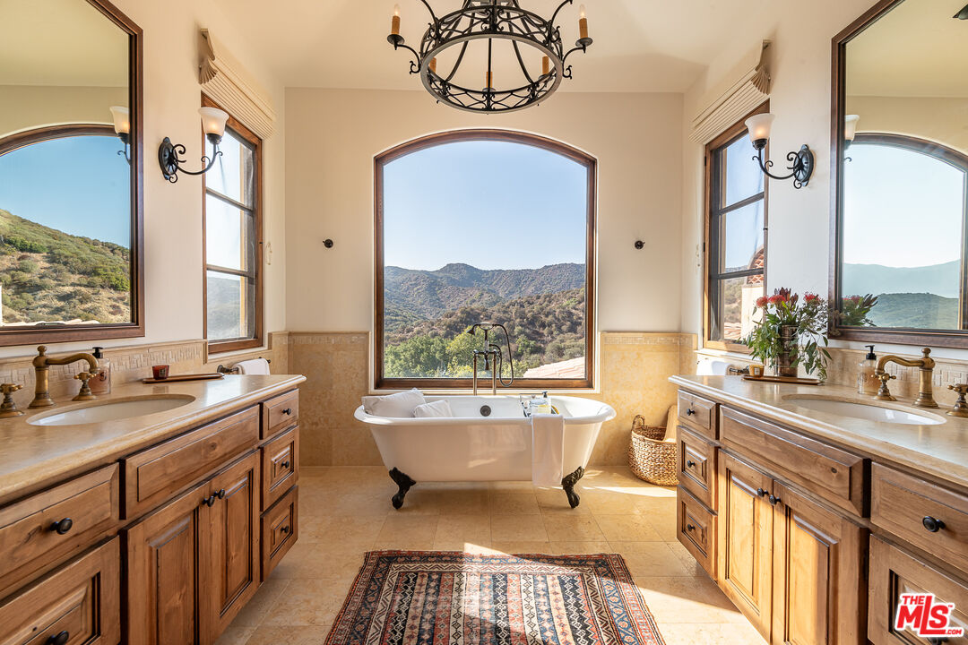 1101 Cold Canyon Road Calabasas, CA 91302 - Photo 26 of 60 a spacious bathroom with a double vanity sink a mirror and a bathtub