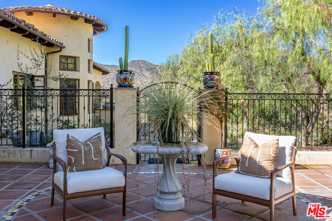1101 Cold Canyon Road Calabasas, CA 91302 - Photo 39 of 60 a view of a patio with couches table and chairs and potted plants