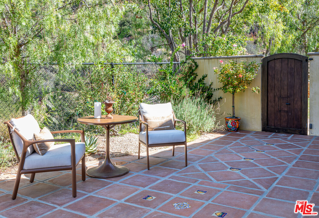 1101 Cold Canyon Road Calabasas, CA 91302 - Photo 41 of 60 a chair and table sitting in backyard of a house
