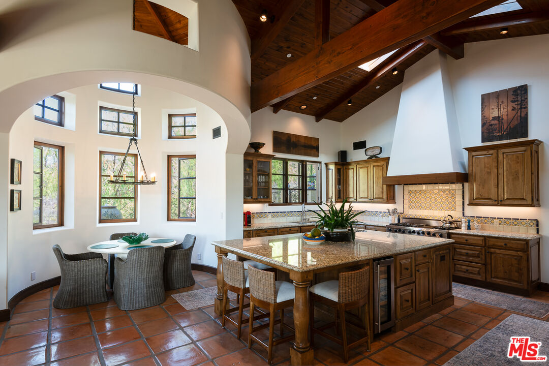 1101 Cold Canyon Road Calabasas, CA 91302 - Photo 10 of 60 a kitchen with stainless steel appliances granite countertop a stove a sink dishwasher and cabinets with wooden floor
