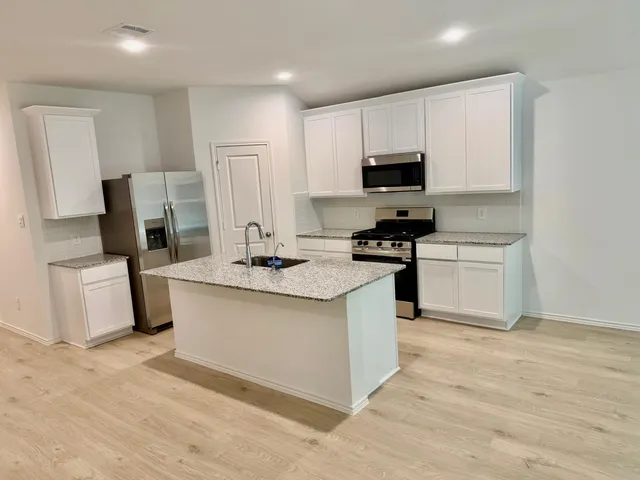 a kitchen with stainless steel appliances a refrigerator stove and microwave