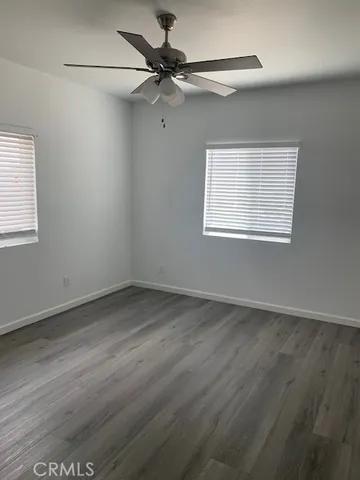 an empty room with a window and a fan