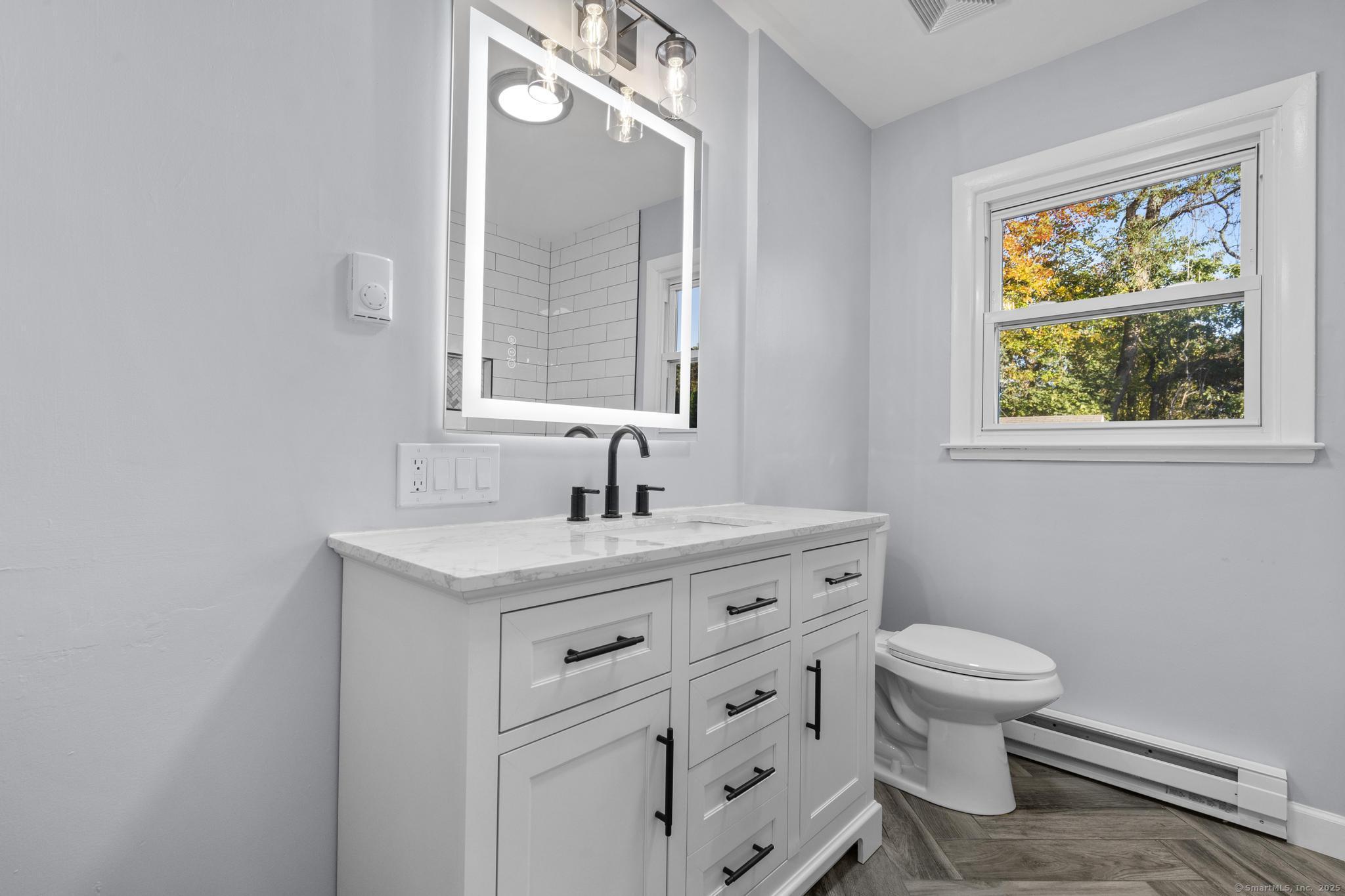 99 Roosevelt Avenue West Haven, CT 06516 - Photo 12 of 27 a bathroom with a granite countertop sink toilet and a window