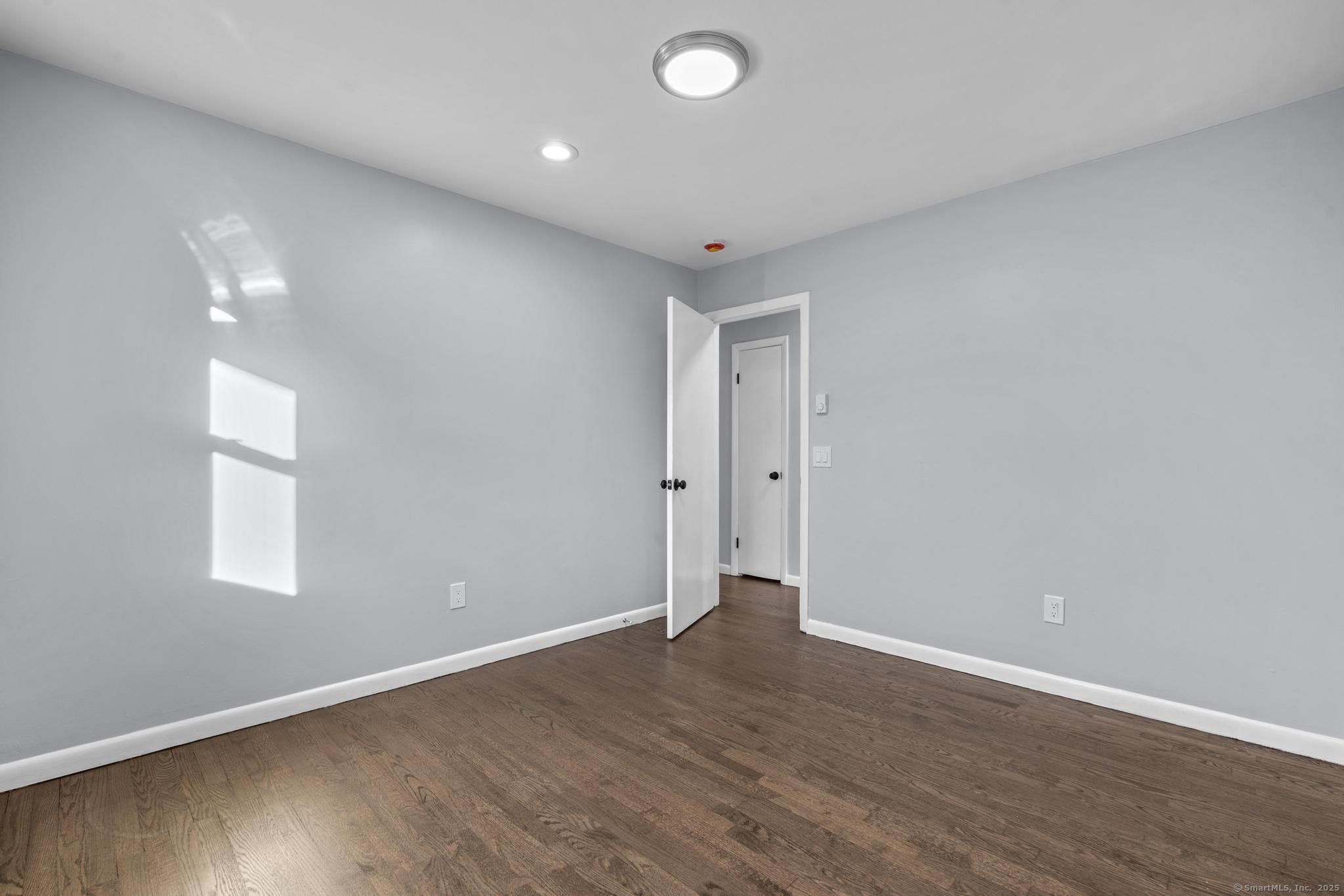 99 Roosevelt Avenue West Haven, CT 06516 - Photo 9 of 27 a view of an empty room with wooden floor and a window