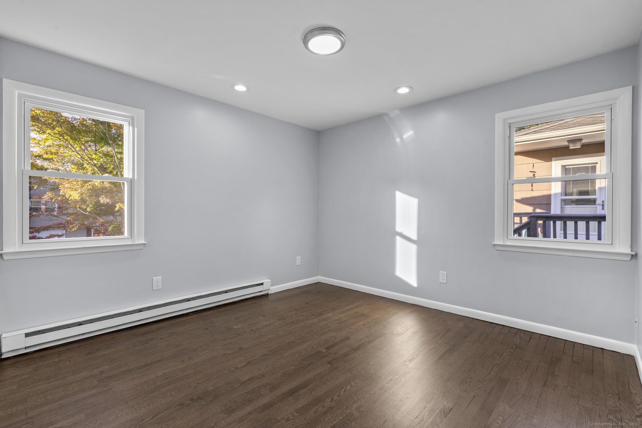 99 Roosevelt Avenue West Haven, CT 06516 - Photo 10 of 27 a view of empty room with wooden floor and fan