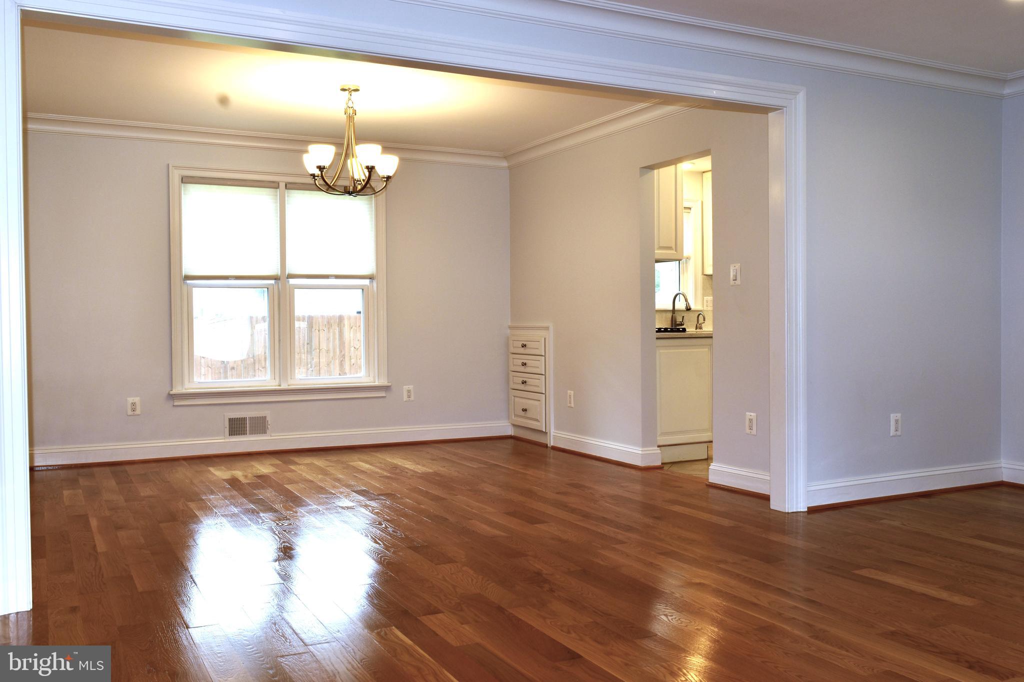 11514 Seven Locks Road Potomac, MD 20854 - Photo 21 of 72 an empty room with wooden floor chandelier and windows