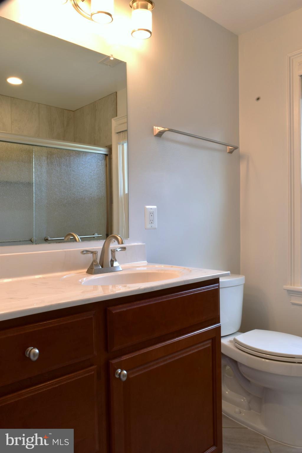 11514 Seven Locks Road Potomac, MD 20854 - Photo 33 of 72 a bathroom with a sink a toilet a mirror and vanity