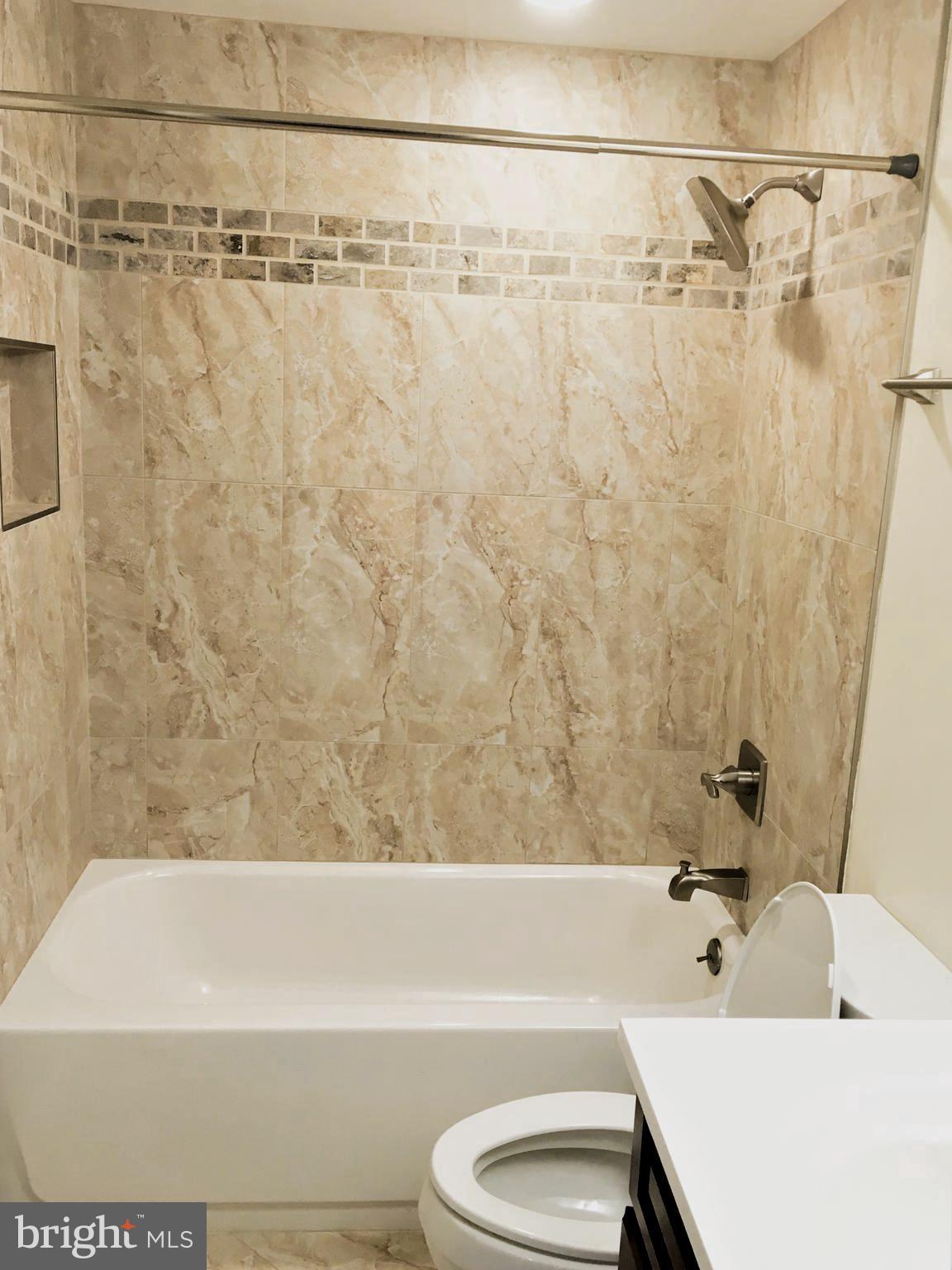 11514 Seven Locks Road Potomac, MD 20854 - Photo 57 of 72 a bathroom with a white bath tub and a shower curtain