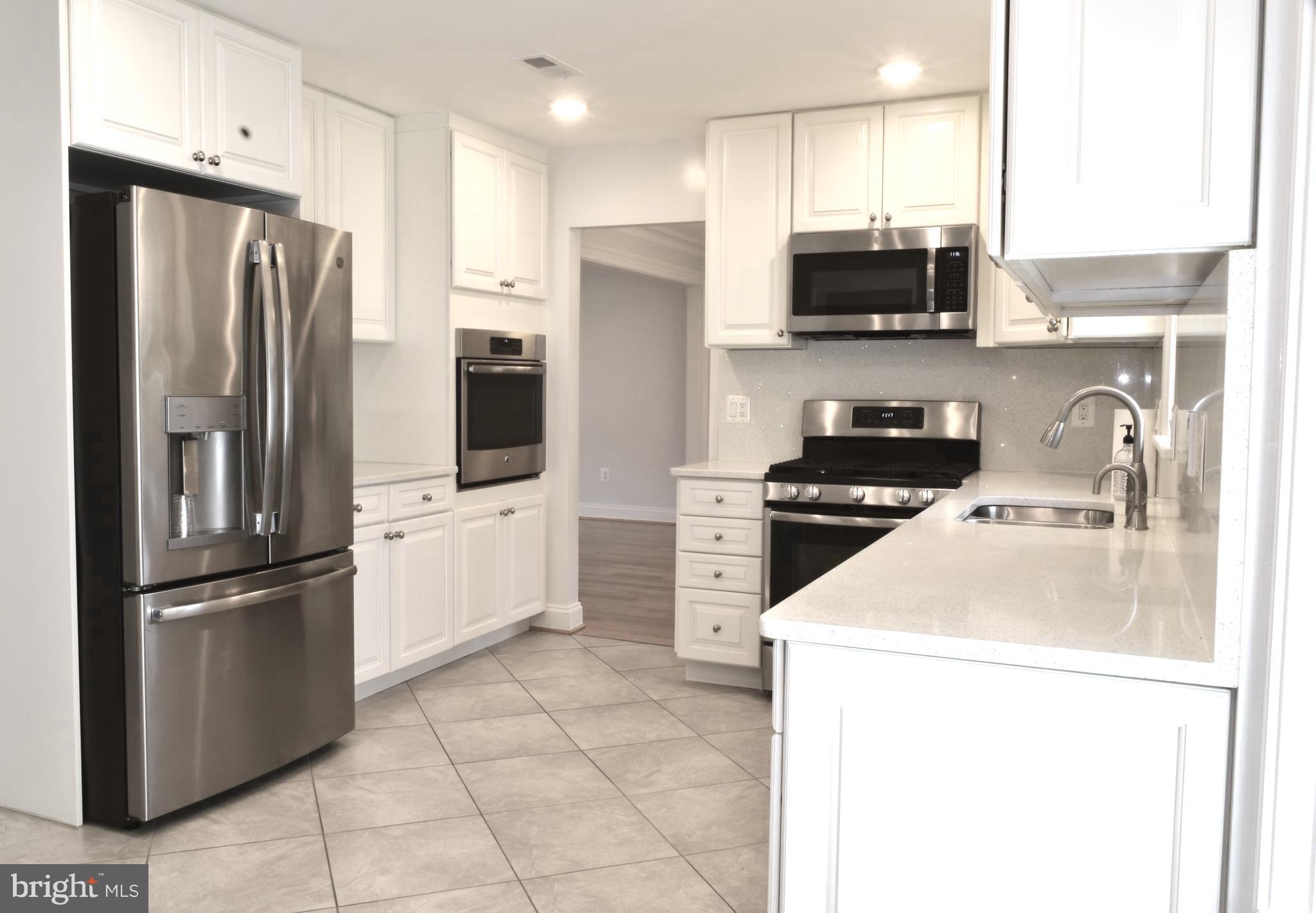 11514 Seven Locks Road Potomac, MD 20854 - Photo 9 of 72 a kitchen with stainless steel appliances a refrigerator sink and microwave
