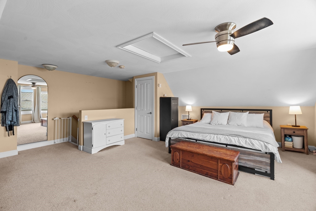 146 South Pleasant Street, Unit 146 Haverhill, MA 01835 - Photo 23 of 28 a spacious bedroom with a bed and a chandelier
