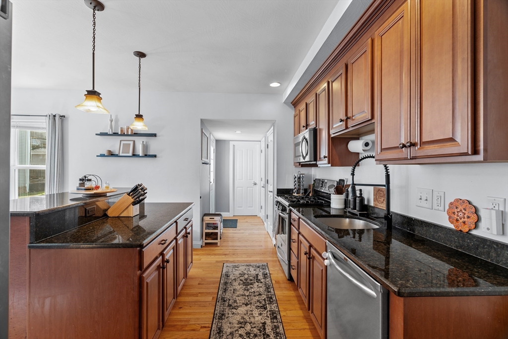 146 South Pleasant Street, Unit 146 Haverhill, MA 01835 - Photo 4 of 28 a kitchen with granite countertop a sink a stove and refrigerator