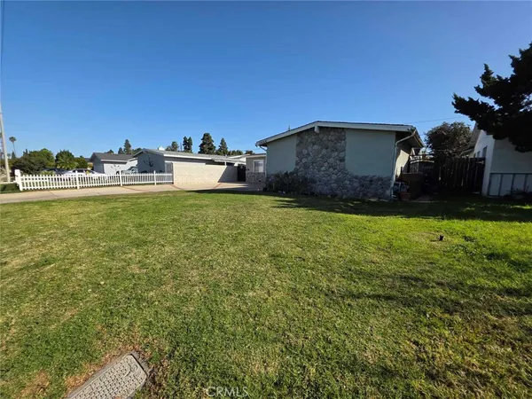 a backyard of a house with lots of green space and mountain view in back