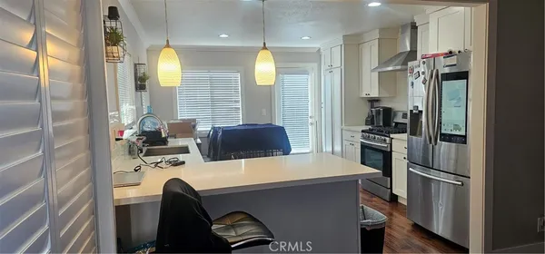 a kitchen with a refrigerator a stove and a sink with wooden floor