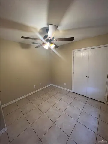 an empty room with a ceiling fan and carpet