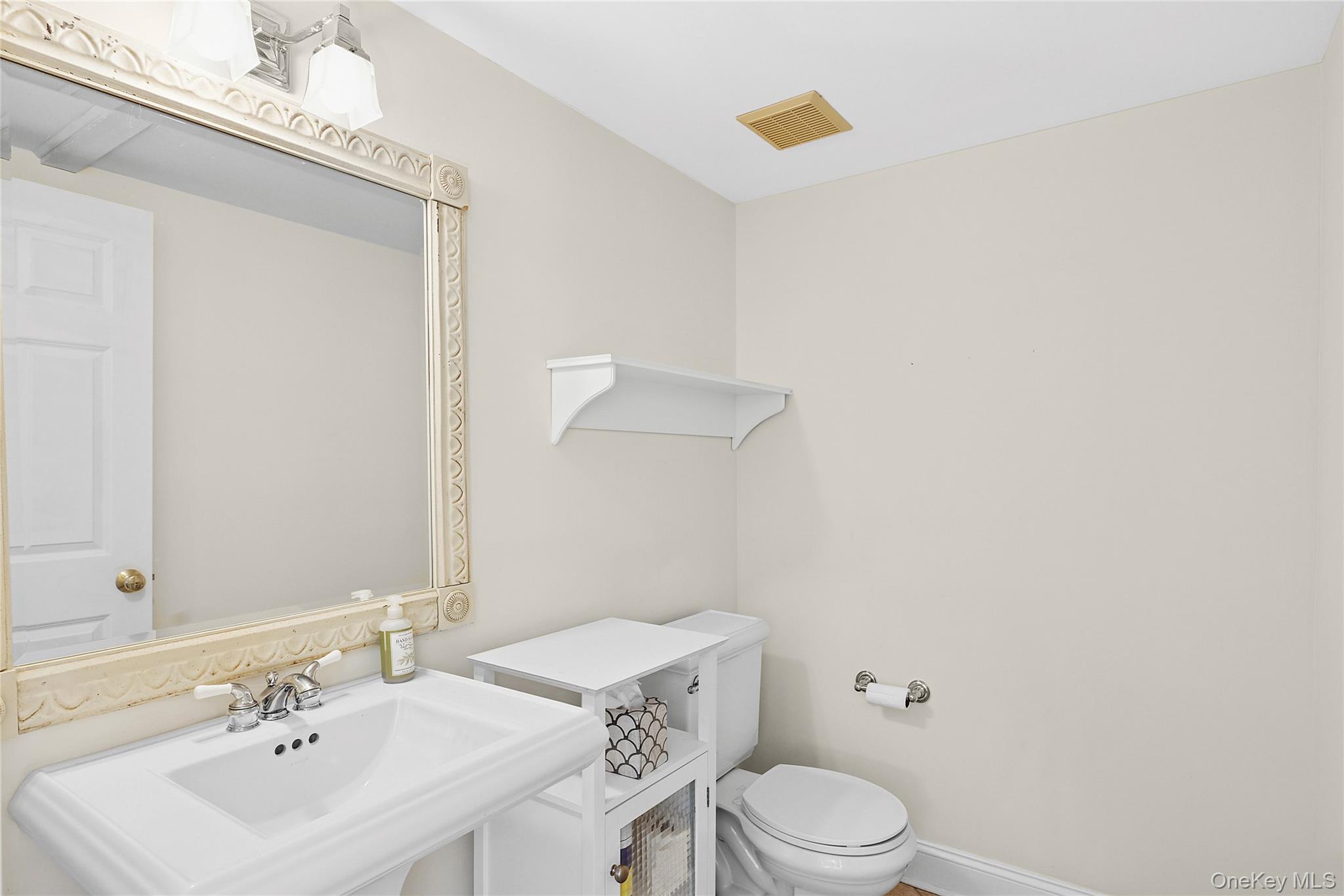 22 Old Trail Road Water Mill, NY 11976 - Photo 12 of 38 a bathroom with a sink a toilet and mirror