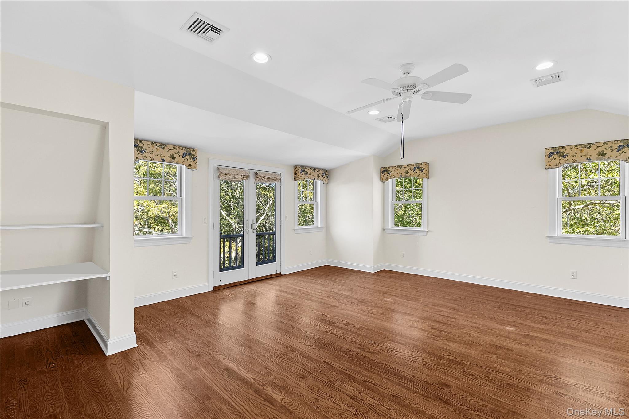 22 Old Trail Road Water Mill, NY 11976 - Photo 18 of 38 an empty room with wooden floor chandelier fan and windows
