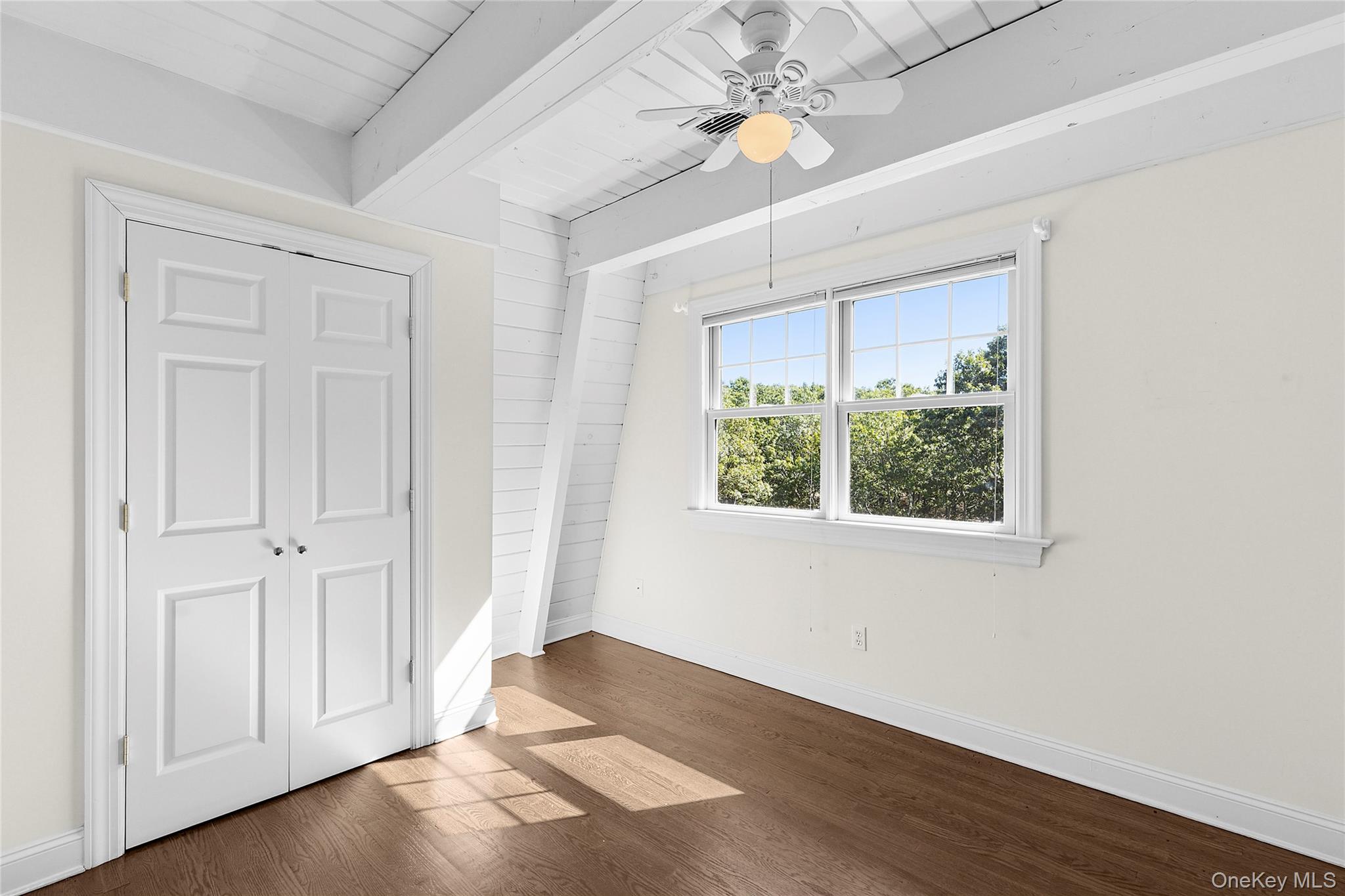 22 Old Trail Road Water Mill, NY 11976 - Photo 23 of 38 an empty room with wooden floor fan and windows