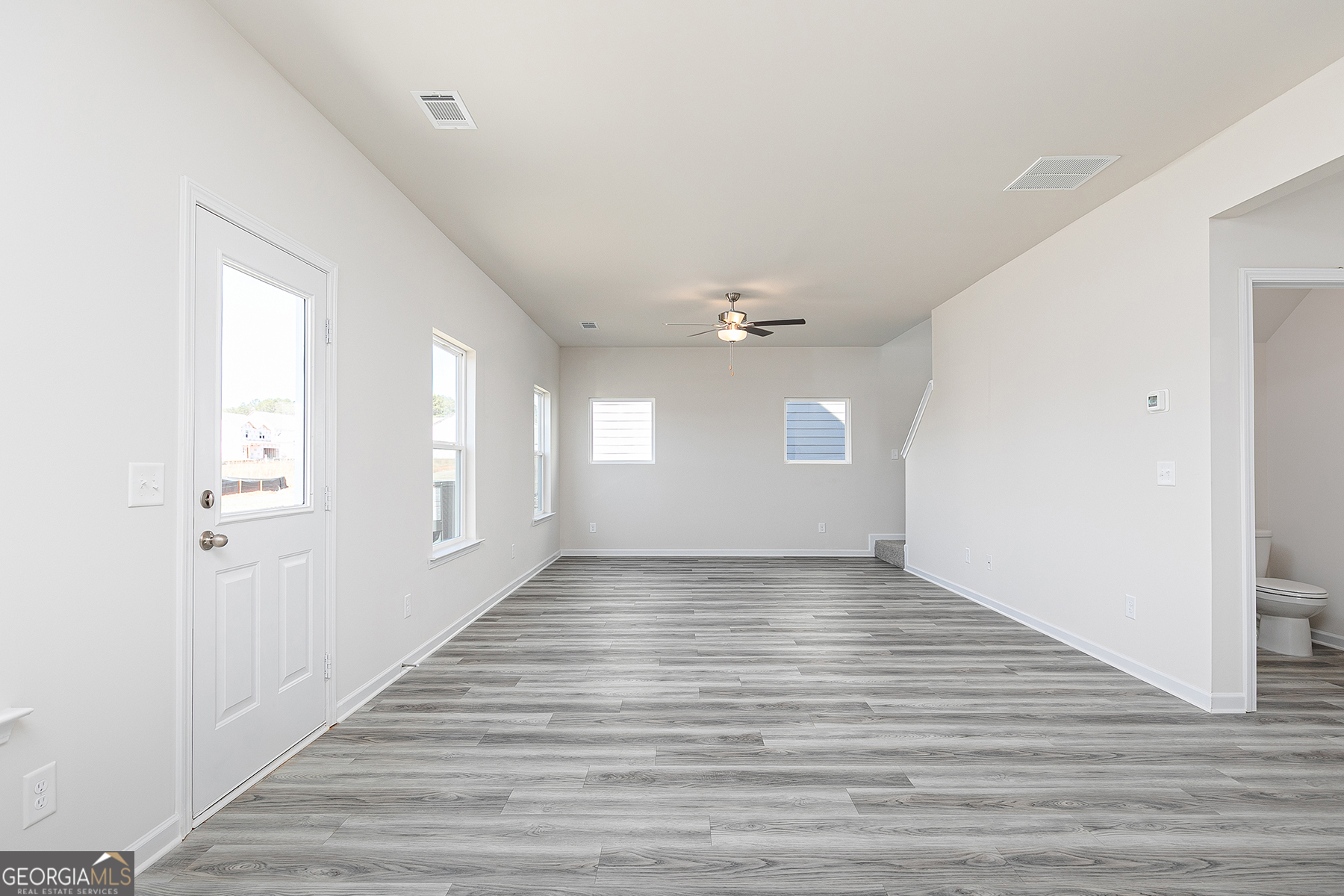 661 Mackenzie Cove Villa Rica, GA 30180 - Photo 6 of 18 a view of an empty room with wooden floor and a window