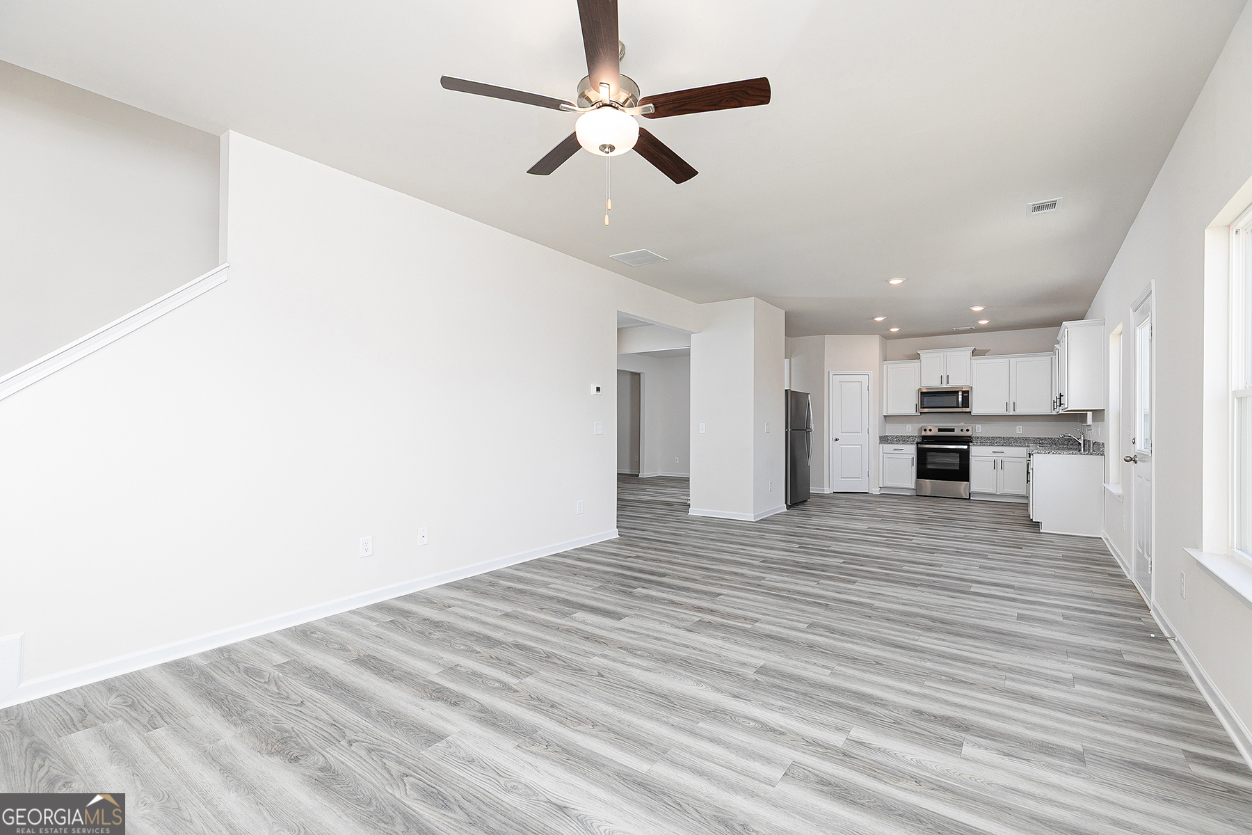 661 Mackenzie Cove Villa Rica, GA 30180 - Photo 7 of 18 a view of kitchen and empty room with wooden floor