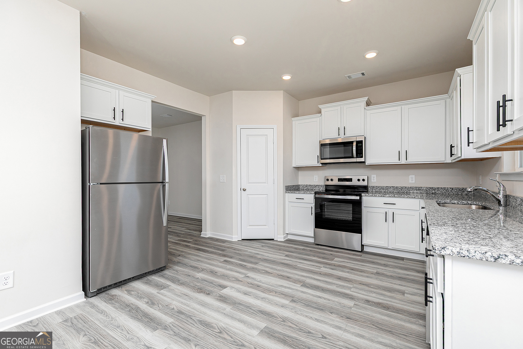 661 Mackenzie Cove Villa Rica, GA 30180 - Photo 10 of 18 a kitchen with granite countertop a refrigerator stove and white kitchen island