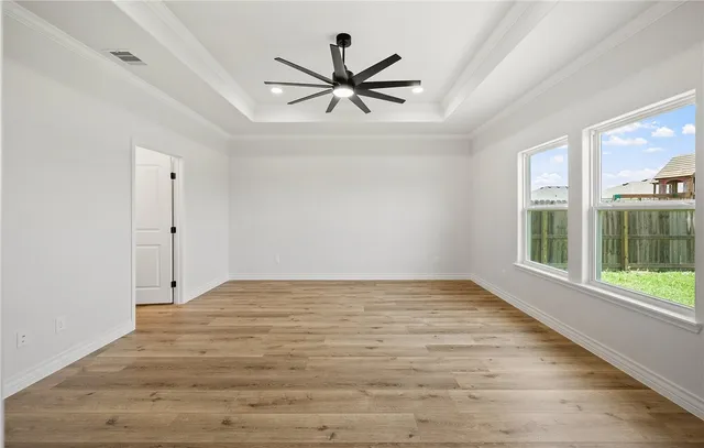 a view of empty room with wooden floor and fan