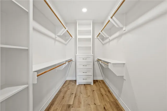 a view of walk in closet with wooden floor and stairs