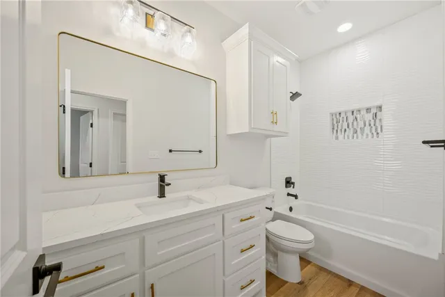 a bathroom with a toilet sink a mirror and shower