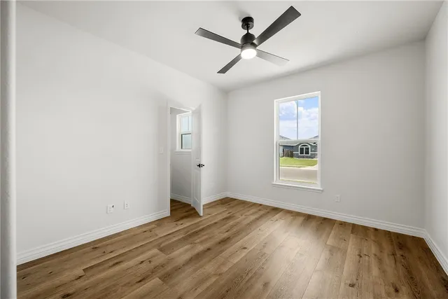 a view of a big room with wooden floor and windows