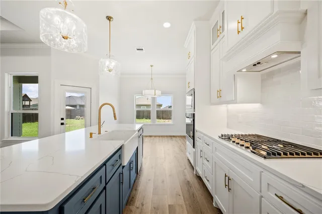a large kitchen with kitchen island a large counter space a sink stainless steel appliances and cabinets