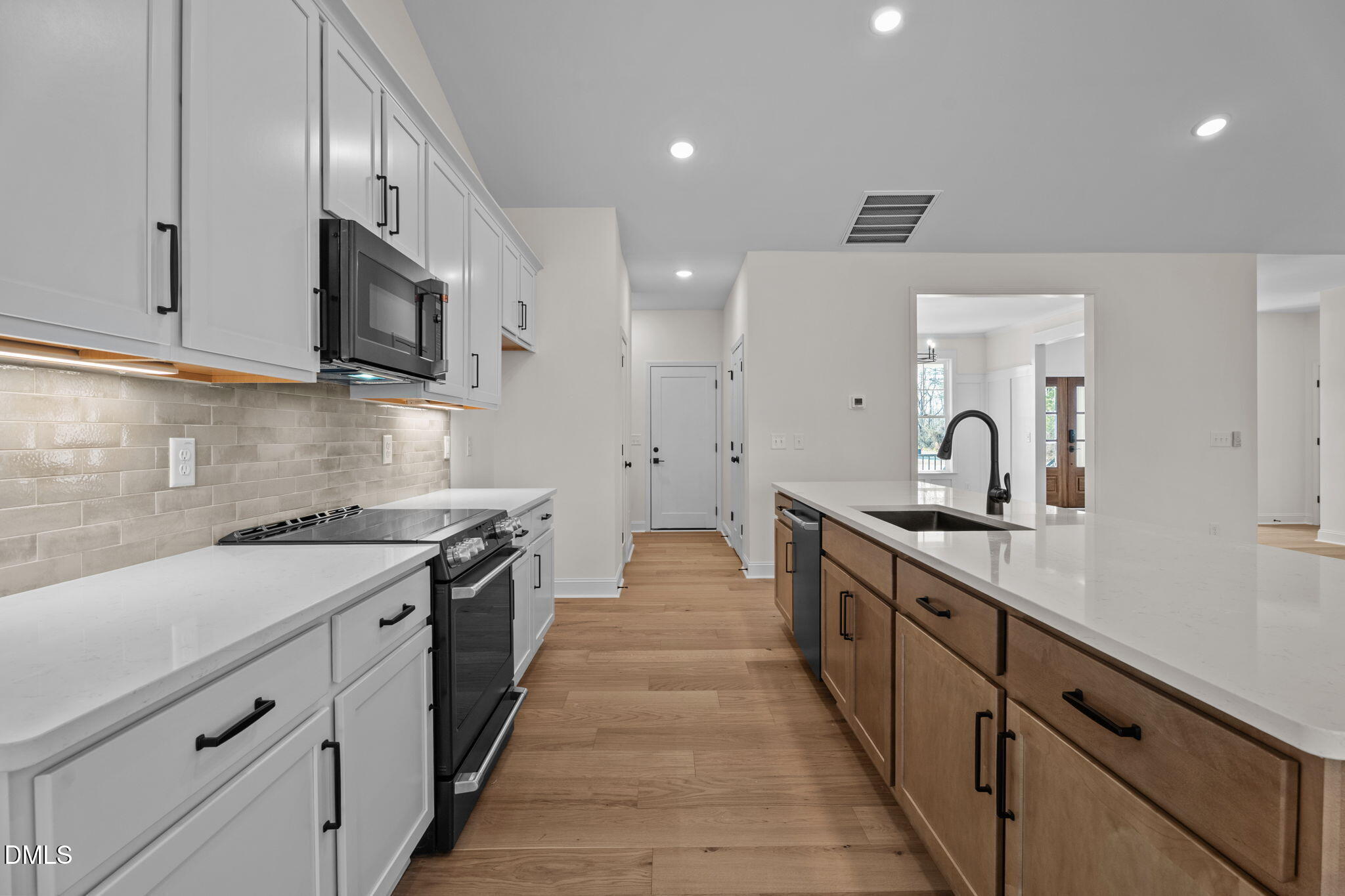 2396 Heartland Road Battleboro, NC 27809 - Photo 28 of 49 a large kitchen with stainless steel appliances granite countertop a sink and dishwasher a stove top oven with wooden floor