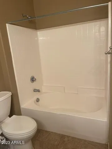a white toilet sitting next to a bath tub and a shower