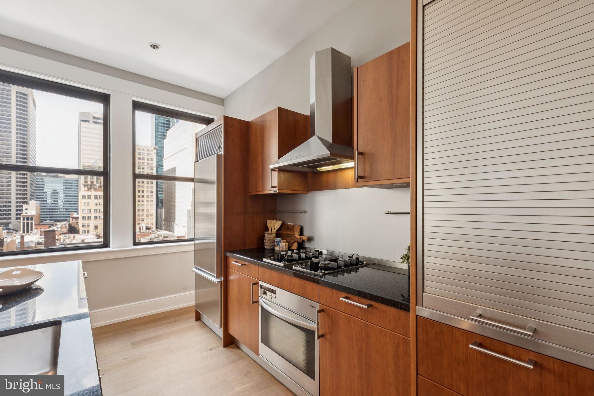 1515 Locust Street, Unit 800 Philadelphia, PA 19102 - Photo 11 of 59 a kitchen with stainless steel appliances granite countertop white cabinets and a window