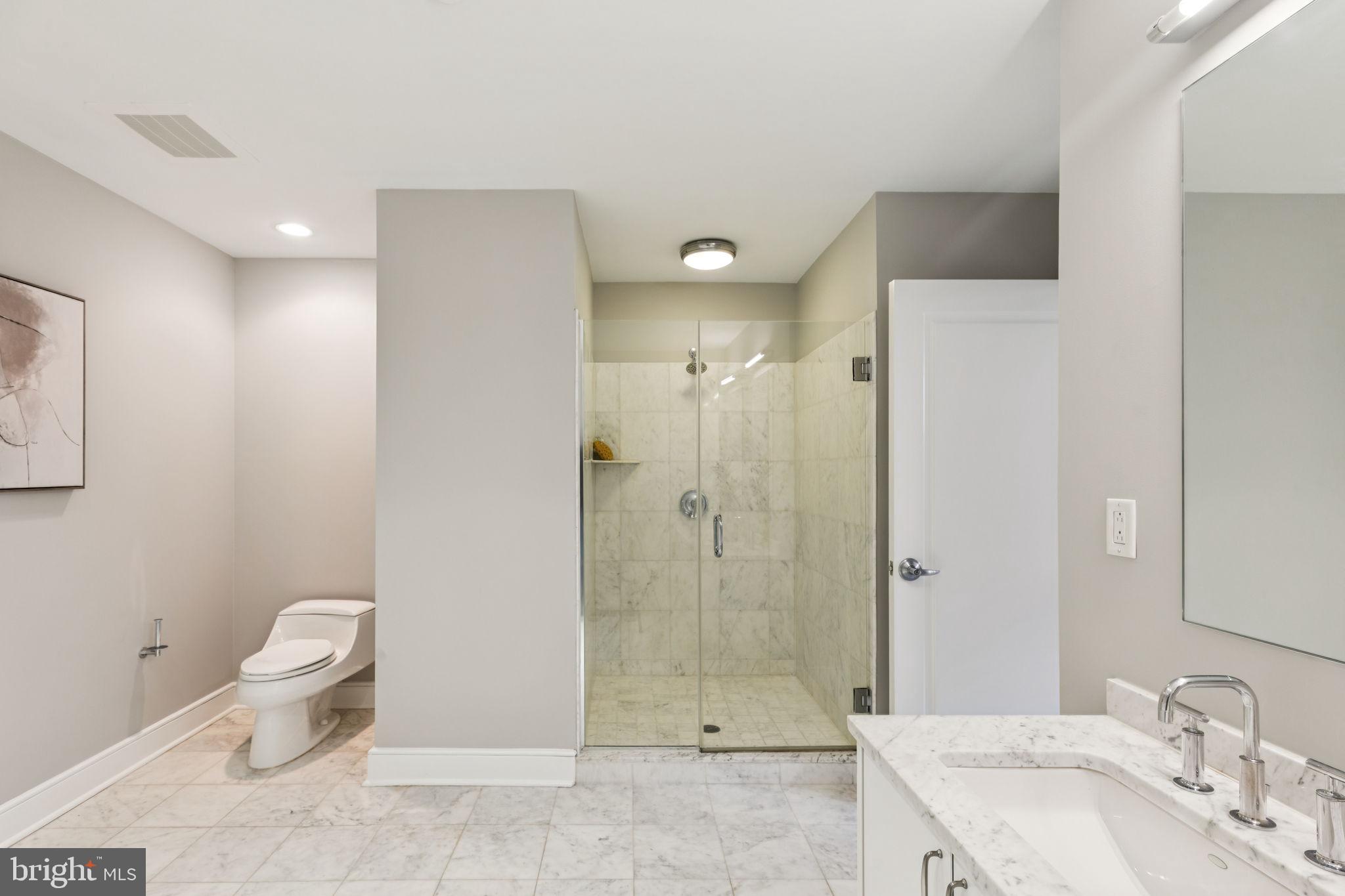 1515 Locust Street, Unit 800 Philadelphia, PA 19102 - Photo 43 of 59 a bathroom with a granite countertop sink a toilet and shower